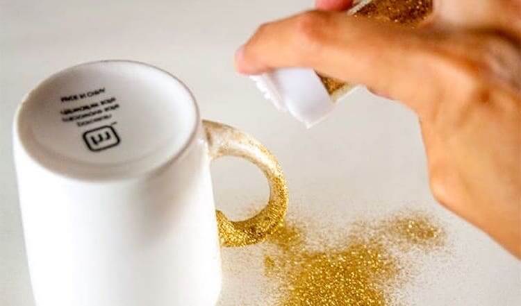 Dishwasher safe gold glitter being sprinkled on mug as decoration.