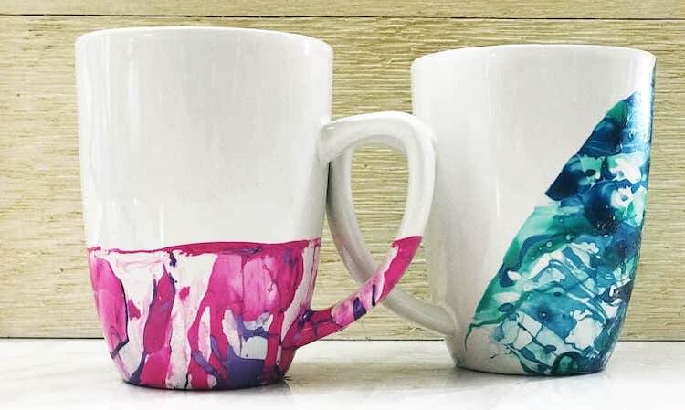 Glossed ceramic coffee mugs with nail polish marble design effect.