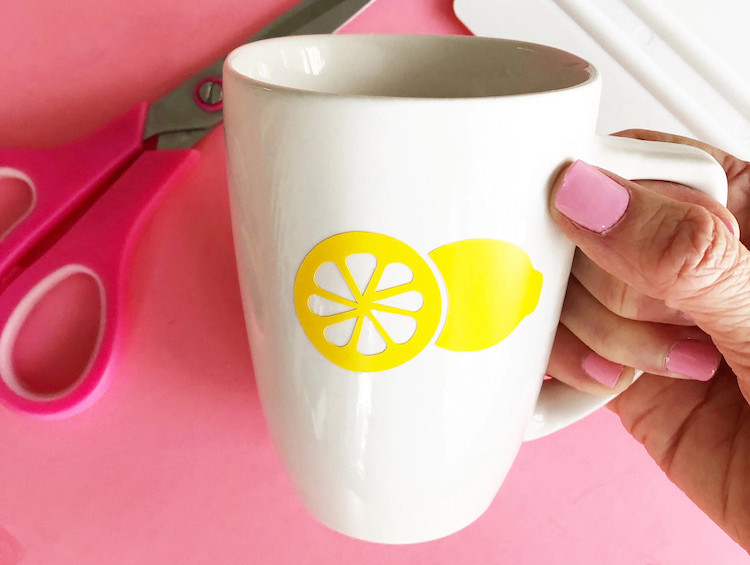 Bright yellow vinyl decals of a lemon applied to ceramic coffee cup.
