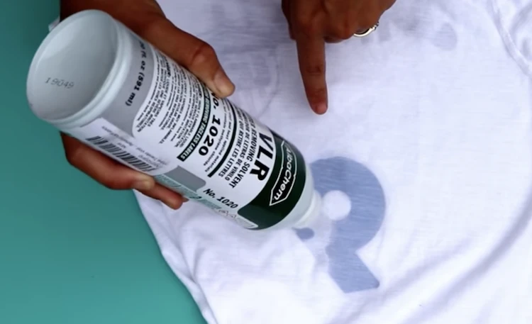 Screen print operator soaking ink with Acetone in order to remove artwork from a t-shirt.