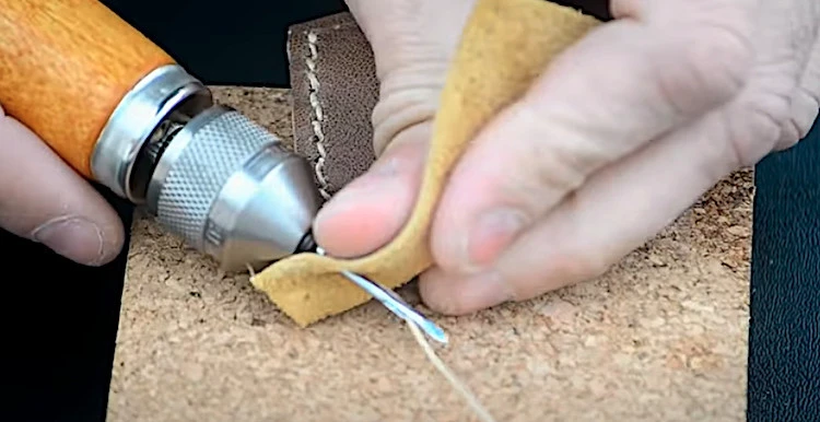 man hand sewing a patch onto fabric