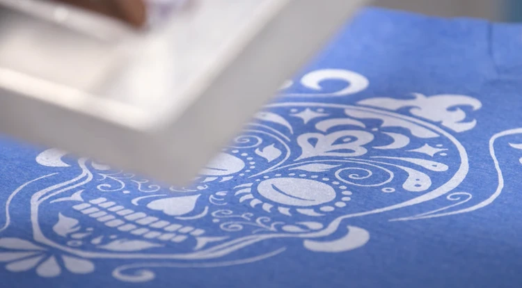 Blue cotton t-shirt having spot color printed on it using screen printing process.