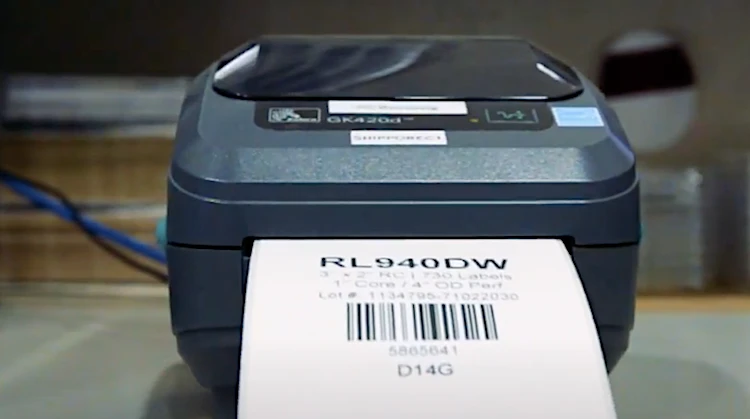 Zebra GK420t direct thermal printer printing bar code on shipping label.