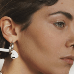 lady hanging wireless earbuds on her earrings